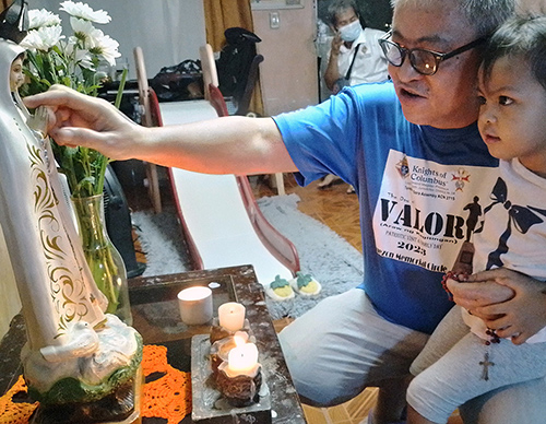 Xenar Dimalanta, a member of Banal na Sakramento Council 8753 in Quezon City, Luzon North, teaches his granddaughter, Hope Felicity, how to pray the rosary during one of the council’s block rosaries in 2023.