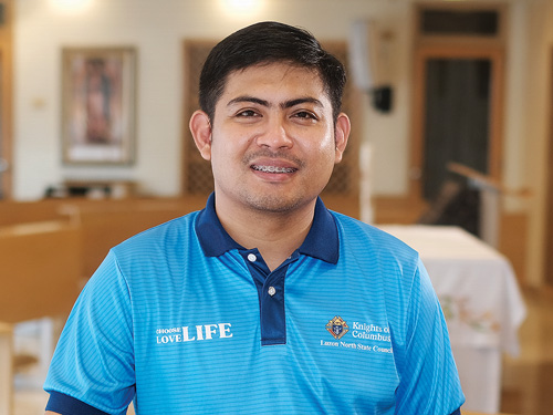 Man in a blue polo shirt poses for a portrait