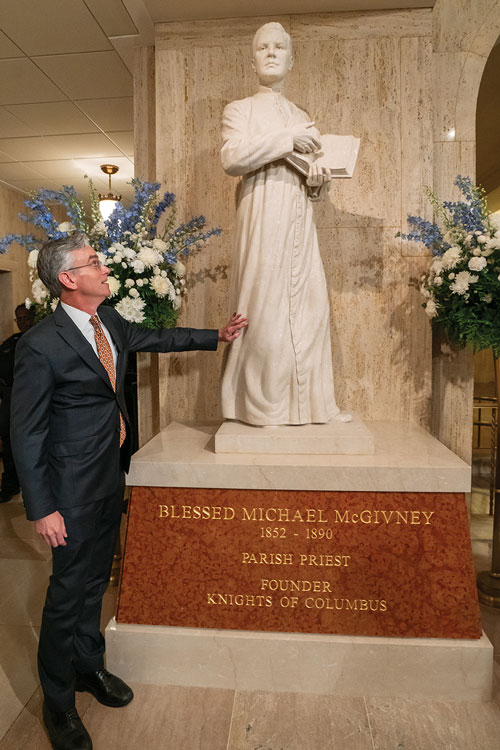 Artist Chas Fagan looks up at his statue of Blessed Michael McGivney after its dedication at the Basilica of the National Shrine of the Immaculate Conception on Dec. 8, 2023. (Photo by Paul Haring)