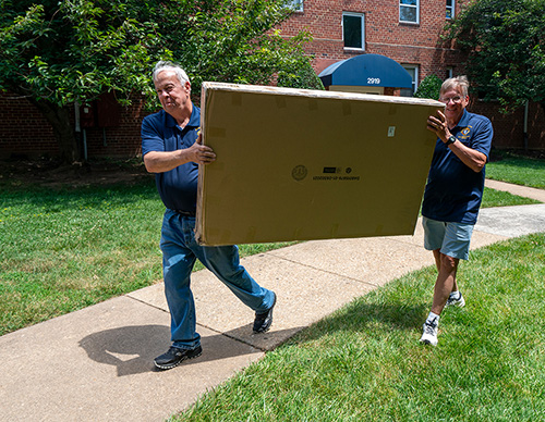 Knights carry a crib to the door of a Project Manger client June 15. (Photo by Matthew Barrick)