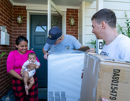 Joe and Michael Jewell deliver a crib and mattress to a young mother and her baby June 15 in northern Virginia. (Photo by Matthew Barrick)