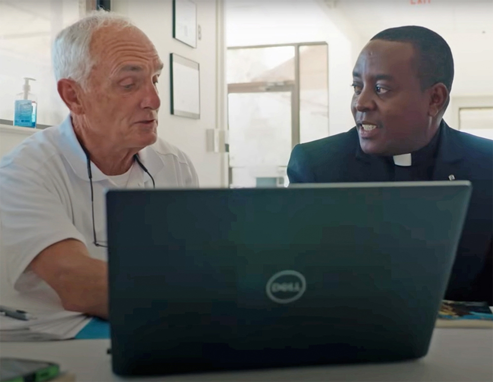 Father Cosmus Wambua speaks with council member Robert Pape, who helped to lead the Knights’ fundraising efforts for the water system in Kambai. (Castletown Media)