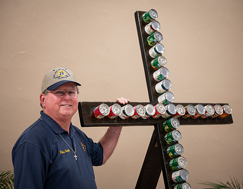 Dennis Chaput, a member of Our Lady of Guadalupe Council 8306, stands with a cross that his son-in-law built to promote the 40 Cans for Lent food drive at Our Lady of Guadalupe Catholic Church in Helotes, Texas. 