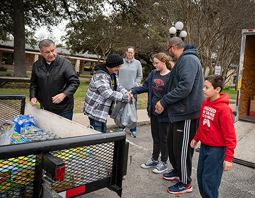 James Charvet of Our Lady of Guadalupe Council 8306 accepts a donation from a family outside Our Lady of Guadalupe Catholic Church in Helotes, Texas, during the council’s kickoff event for its 40 Cans for Lent food drive Feb. 17. (Photo by Ethan E. Rocke)