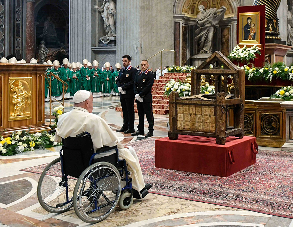 Pope Francis prays before the Chair of St. Peter, placed in front of the main altar of St. Peter’s Basilica, after the closing Mass of the Synod of Bishops on synodality at the Vatican on Oct. 27. (CNS photo/Vatican Media)