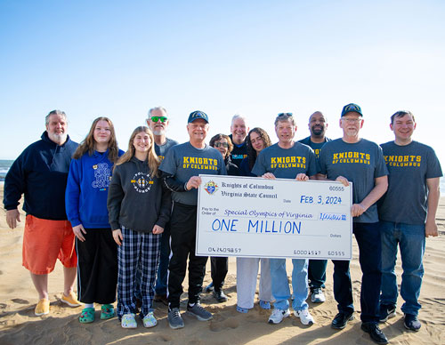 Led by State Deputy Patrick Rowland (fourth from right), K of C leaders and family members present a check representing the $1 million that Virginia Knights have raised through Polar Plunges to Special Olympics Virginia president Dave Thomason (back, center) at the Polar Plunge Festival in Virginia Beach, Va., Feb. 3. (Courtesy of Special Olympics Virginia)