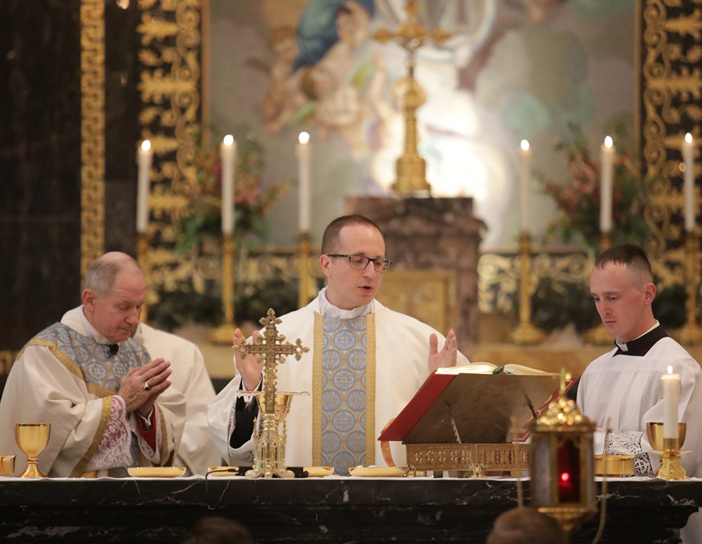 Father Zachary Samples (center) prays during the Liturgy of the Eucharist after being ordained a priest May 28, 2022, by Bishop Thomas Paprocki (left) at the Cathedral of the Immaculate Conception in Springfield, Ill. Father Samples, a member of Quincy Council 583, received RSVP support from Our Lady of the Holy Spirit Council 11582 in Mount Zion throughout his years in seminary.