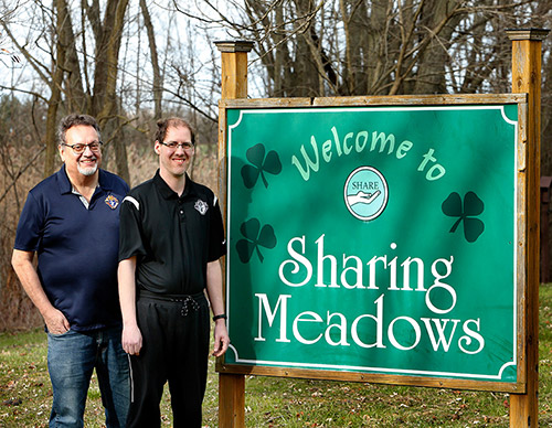 Mike Catania and his son Steven, both members of Nativity of Our Savior Council 9114 in Portage, Ind., stand in front of the welcome sign at Sharing Meadows in La Porte, Ind., where Steven is a resident. (Photo by Karen Callaway)