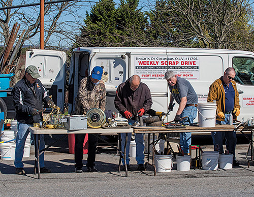 Grand Knights Bill Traube (second from right) and other Knights sort items containing metal donated during a collection at Holy Family Parish in Middletown, Md. (Photo by Matthew Barrick)