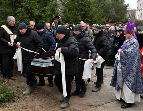 The coffin of Denys Tarasov, a member of God the Merciful Father Council 16460 killed in battle, is carried to a grave in Zaporizhzhia, Ukraine, Jan. 13, 2023. 