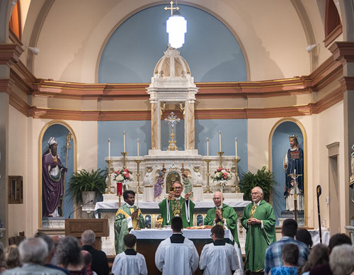 Bishop Patrick Neary of St. Cloud, Minn., celebrates Mass in the newly restored St. Edward’s Church on June 29, the first Mass offered in the church since a fire last July and the official installation Mass of Father Jimmy Joseph, left, as pastor. (Photo by Kimm Anderson)