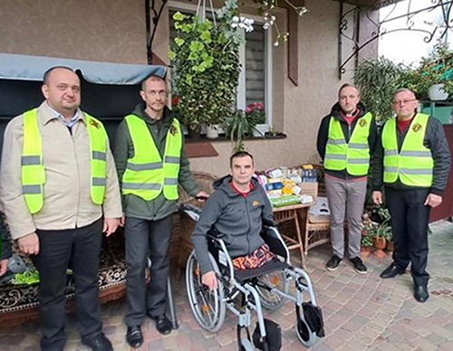 Knights deliver a wheelchair to combat veteran Mykola V’yuk at his home in the Rivne region of Ukraine.