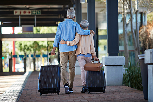 Traveling retired couple holding each other