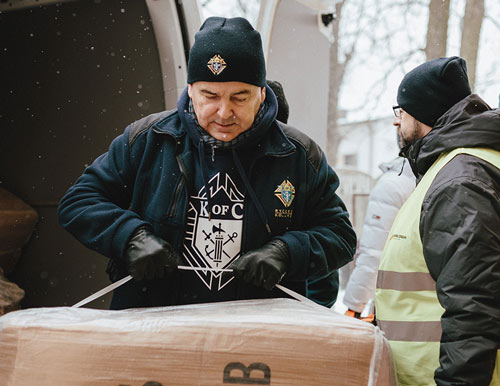 District Deputy Marek Tyka, a member of Our Lady of Częstochowa Council 14004 in Radom, Poland, and other Knights unload a shipment of children’s coats last winter. 