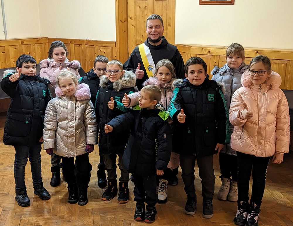 Students in Ternopil, Ukraine, express approval for the coats they received from St. Peter’s Council 17487 last December. The children attend a school run by the Franciscan Monastery of the Nativity of the Holy Mother of God in Ternopil; Franciscan Brother Tryfon (center) is a member of Council 17487.